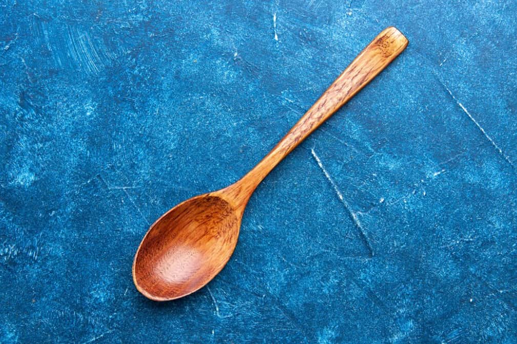 A wooden spoon on a textured blue background