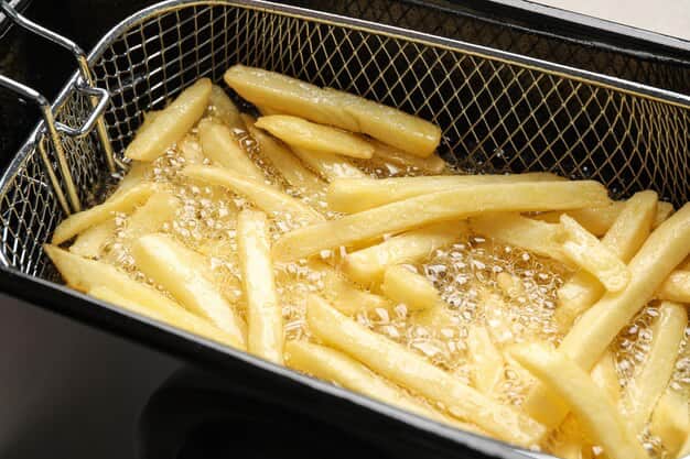 Close-up of cooking French fries in hot oil