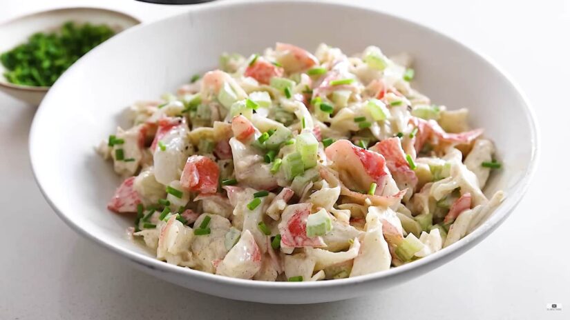 A bowl of crab salad garnished with green onions