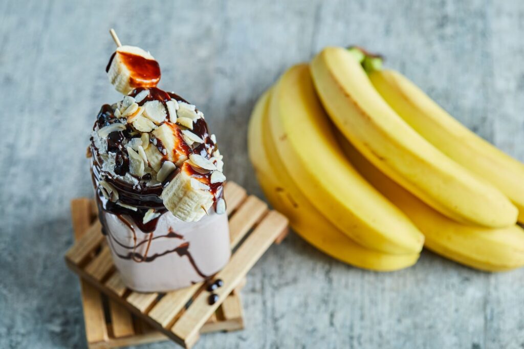 Ice cream with choco syrup and a branch of bananas