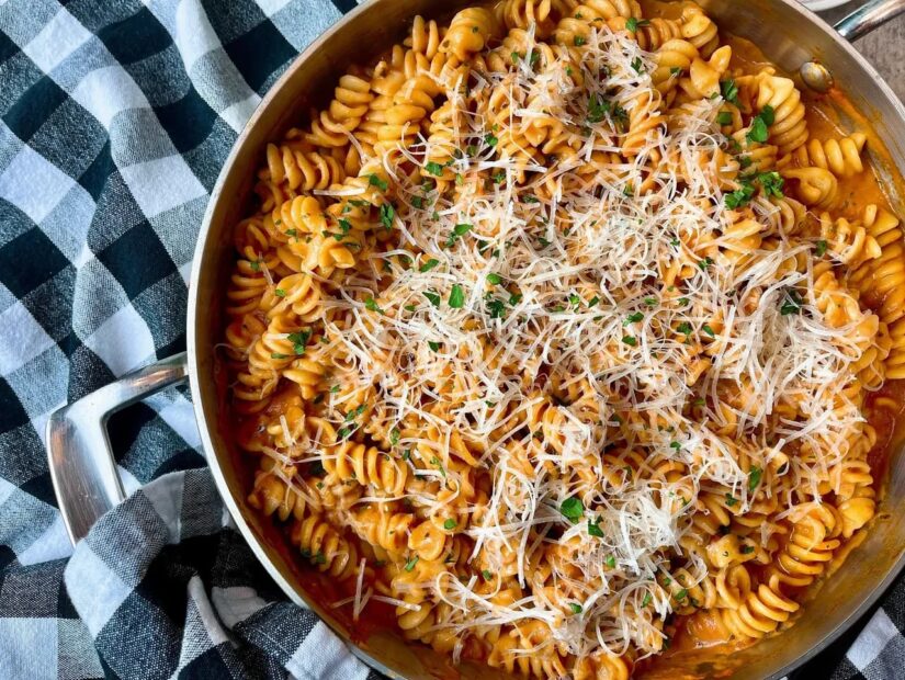 Pasta in a skillet with cheese and herbs